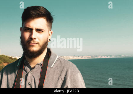 Jeune et bel homme avec barbe posing in front of camera Banque D'Images