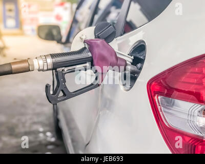 La buse de carburant à ajouter du carburant dans la voiture à la station d'essence. Banque D'Images