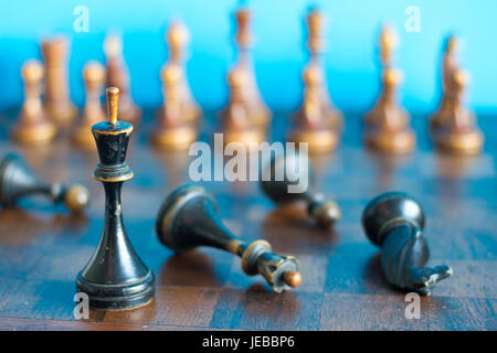 Pièces des échecs en bois ancienne sur un ancien échiquier. Sur un fond bleu. Banque D'Images