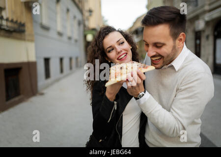 Happy young Couple partageant une pizza cut Banque D'Images