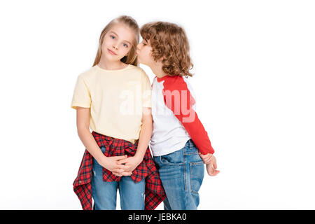 Little girl looking at camera while boy essayant de l'embrasser, isolated on white Banque D'Images