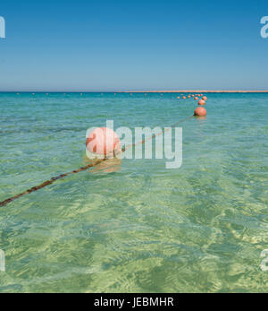 Ligne de bouées orange flottant sur corde en lagune de plage tropicale Océan mer Banque D'Images