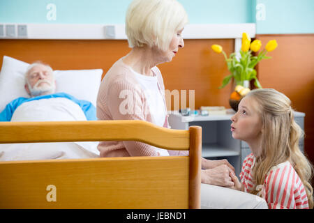 Portrait de grand-mère et petite-fille bouleversé la visite à l'hôpital du patient. Banque D'Images