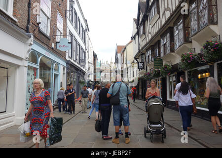 Les touristes et les consommateurs sur la rue piétonne animée de Stonegate à York, Royaume-Uni Banque D'Images