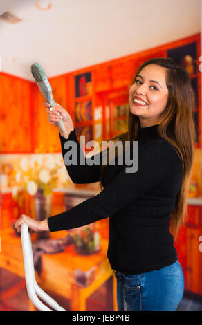 Belle jeune femme peinture plafond à l'aide pinceau Banque D'Images