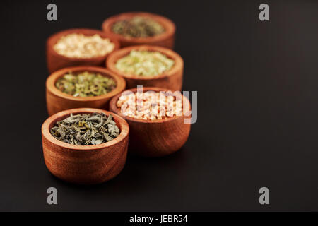Assortiment de thé sec dans des bols peu Banque D'Images