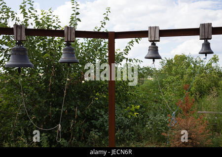 Quatre cloches de l'église. Les cloches de l'église sont sur une croix de métal-faisceau. Banque D'Images