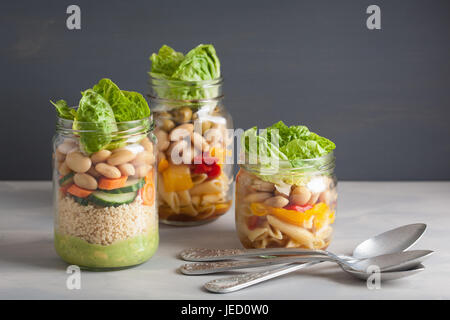 Salade de pâtes et de couscous végétalien dans des pots Mason avec haricots Légumes Banque D'Images