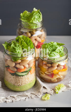 Salade de pâtes et de couscous végétalien dans des pots Mason avec haricots Légumes Banque D'Images