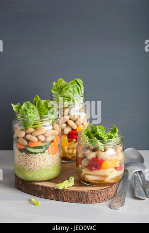 Salade de pâtes et de couscous végétalien dans des pots Mason avec haricots Légumes Banque D'Images