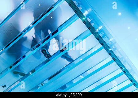 Escalier en verre moderne avec personne marchant Banque D'Images