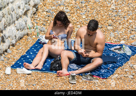 Jeune couple en train de bronzer sur une plage à sa manière. Banque D'Images