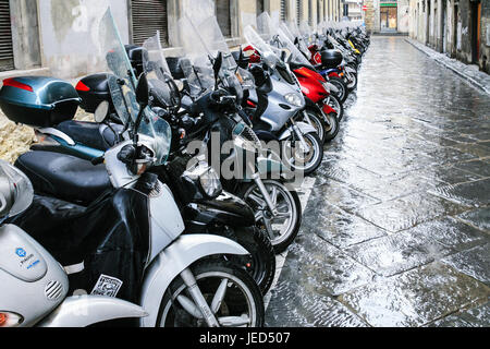 FLORENCE, ITALIE - 7 janvier 2009 : de nombreux vélos stationnés dans la rue humide sur la ville de Florence en hiver jour de pluie. Les scooters sont les plus populaires sur les transports urbains Banque D'Images