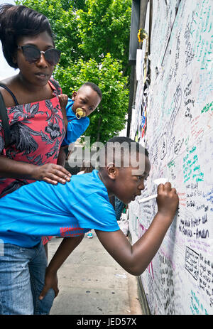 Familles et amis écrit sur le mur de condoléances à la suite de l'incendie qui a détruit la tour de 24 étages Grenfell à North Kensington, Londres le 14 juin 2017. Le nombre de morts officiellement à 75 mais aura sans doute lieu à trois chiffres. Banque D'Images