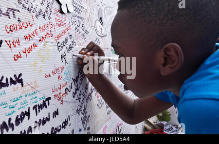 Familles et amis écrit sur le mur de condoléances à la suite de l'incendie qui a détruit la tour de 24 étages Grenfell à North Kensington, Londres le 14 juin 2017. Le nombre de morts officiellement à 75 mais aura sans doute lieu à trois chiffres. Banque D'Images