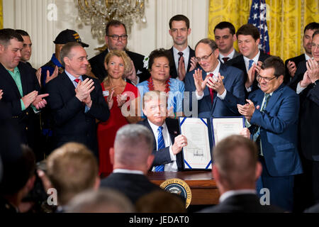 Washington, USA. 23 Juin, 2017. Le Président américain Donald Trump (C) affiche les documents après la signature à la Maison Blanche à Washington, DC, États-Unis, le 23 juin 2017. Le Président américain Donald Trump le vendredi a signé une nouvelle loi visant à protéger les dénonciateurs et facilite son congédiement d'employés au ministère des Affaires des anciens combattants (VA). Credit : Ting Shen/Xinhua/Alamy Live News Banque D'Images