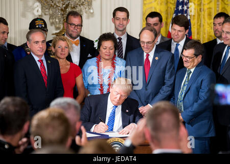 Washington, USA. 23 Juin, 2017. Le Président américain Donald Trump (C) signe les documents à la Maison Blanche à Washington, DC, États-Unis, le 23 juin 2017. Le Président américain Donald Trump le vendredi a signé une nouvelle loi visant à protéger les dénonciateurs et facilite son congédiement d'employés au ministère des Affaires des anciens combattants (VA). Credit : Ting Shen/Xinhua/Alamy Live News Banque D'Images