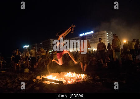 Alicante, Espagne. 24 Juin, 2017. Des milliers de personnes se rassemblent autour de feux de joie au cours de l'Assemblée Feux de la Saint Jean fête dans El plage de Postiguet. Les gens brûlent des objets et faire des souhaits comme ils sautent sur les flammes. Credit : Marcos del Mazo/Alamy live news Banque D'Images