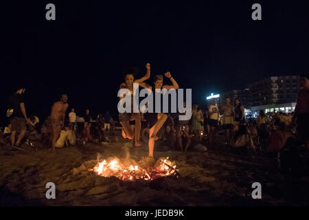 Alicante, Espagne. 24 Juin, 2017. Des milliers de personnes se rassemblent autour de feux de joie au cours de l'Assemblée Feux de la Saint Jean fête dans El plage de Postiguet. Les gens brûlent des objets et faire des souhaits comme ils sautent sur les flammes. Credit : Marcos del Mazo/Alamy live news Banque D'Images