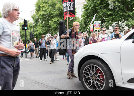 Londres, Royaume-Uni, 24 juin 2017. Les jeunes manifester devant Downing Street contre le gouvernement conservateur qui tente de créer une alliance avec la DUP. Un protestataire se tient debout devant une voiture. Banque D'Images