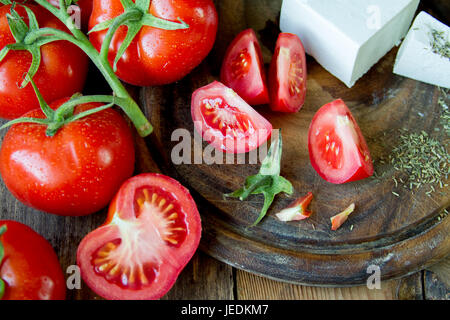 Les tomates et fromage grec blanc sur une planche de bois. Banque D'Images