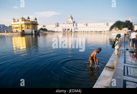 L'Inde, Punjab, Amritsar, l'homme se baigner dans la piscine sacrée du temple d'or complexe. Banque D'Images