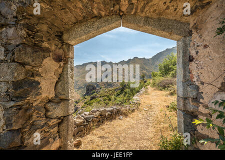 L'entrée en pierre à 'La maison du bandit', le bandit's house, au-dessus du village de Feliceto en Balagne Corse avec des montagnes dans le dist Banque D'Images