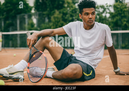 Homme africain et courte pause pendant le jeu de tennis Banque D'Images