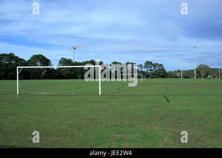 Terrain de football en Australie. Aire de jeux de soccer avec des poteaux de but, projecteurs, d'arbres et d'une grue dans le lointain. Banque D'Images