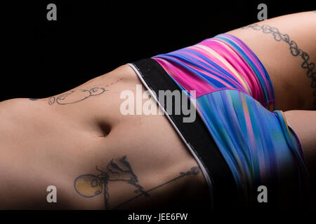 Gros plan du ventre et les hanches d'un athletic young asian woman with tattoos Banque D'Images