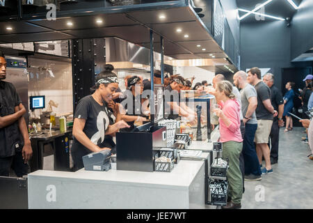 Employés construire une pizza juste avant les yeux des clients en ligne assemblée générale le jour de l'ouverture de la mode &pizza dans leur première pizzeria de New York le mardi, Juin 20, 2017. Pizza &construit ses pizzas dans un style Chipotle avec les accompagnements mis sur une restauration des préférences individuelles des clients. La chaîne de magasins 22, principalement dans la région de Washington DC, les projets de loi lui-même à un établissement avec restaurant créatif de forme oblongue, tartes certains des ingrédients locaux et une ambiance hippie avec '&' tatoué employés appelé la tribu. (© Richard B. Levine) Banque D'Images