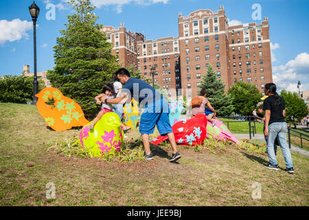 Les visiteurs au parc Joyce Kilmer dans le Bronx à New York le mardi, Juin 20, 2017 Profitez de 'voler haut pour l'égalité' par les artistes Patricia Cazoria et Nancy Saleme. Les moineaux colorés surdimensionnés représentée par l'œuvre sont destinés à être une métaphore de la recherche de l'égalité, la répartition des capacités de sparrow urbain résistance, intelligence et beauté représentés à New York. La sculpture est financé par l'art dans les parcs : Parc UNIQLO. Subvention Expressions (© Richard B. Levine) Banque D'Images