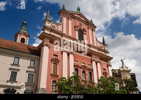 Clocher et façade rose de l'église franciscaine de l'annonciation surmontée par le cuivre statue de Notre Dame de Lorette Ljubljana Slovénie Banque D'Images