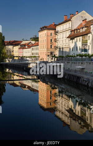 Bâtiments lumineux à l'Ribja Brv passerelle moderne reflète dans le calme de la rivière Ljubljanica canal dans Ljubljana Slovénie Banque D'Images