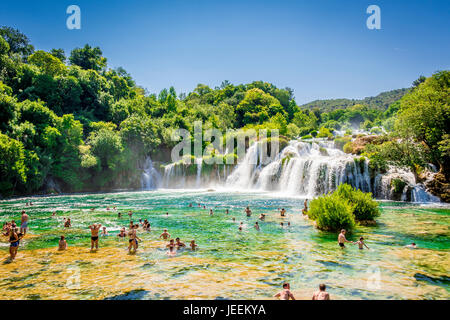 Un couple nager en dessous de la cascade Skradinski buk au Parc National de Krka en Croatie Banque D'Images