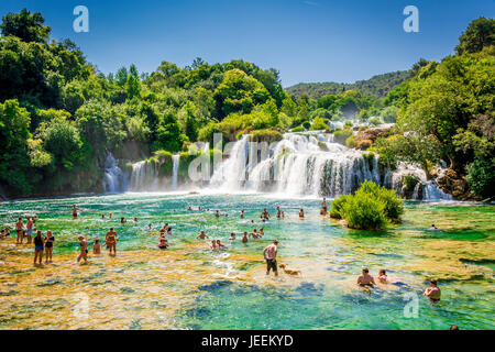 Un couple nager en dessous de la cascade Skradinski buk au Parc National de Krka en Croatie Banque D'Images