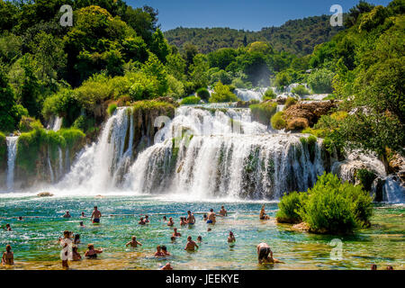 Un couple nager en dessous de la cascade Skradinski buk au Parc National de Krka en Croatie Banque D'Images