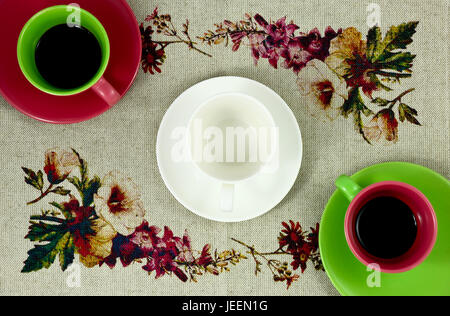 Télévision jeter deux tasses de café couleur vert rouge et blanc dans l'obe midle vide sur le fond coloré avec des fleurs Banque D'Images