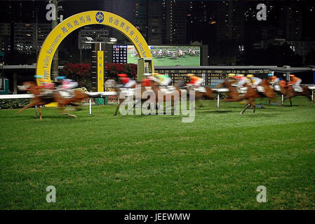 Vue horizontale des chevaux de croisement au poteau à l'hippodrome de Happy Valley à Hong Kong, Chine. Banque D'Images