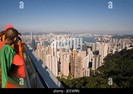 Vue horizontale de moines bouddhistes profitant de la vue depuis le sommet de Hong Kong, Chine. Banque D'Images