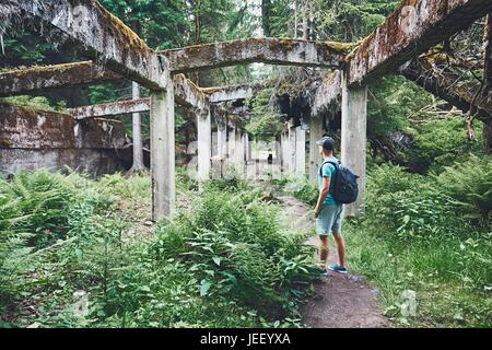 Les jeunes à l'intérieur de l'explorateur de l'ancienne usine abandonnée en ruine au milieu de la forêt. Monts métallifères, République Tchèque Banque D'Images