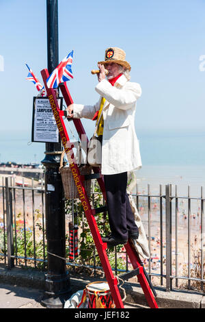 M. William Thompkins, Lamplighter, Charles Dickens caractère, histoire. Vêtu de blanc manteau et chapeau de paille, se dresse sur l'échelle contre la lumière avec Union Jack. Banque D'Images