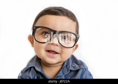 Parution modèle photo d'un mignon, drôle à la baby boy wearing eyeglasses and smiling at the camera against a white background Banque D'Images