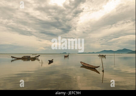 Des bateaux de pêche vietnamiens traditionnels Sampan appelée (trois planches) sur un lac dans le centre du pays entre les villes de Hoi An et Hué au lever du soleil, de l'Asie. Banque D'Images