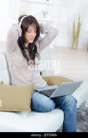 Femme à la maison à regarder film sur ordinateur portable Banque D'Images