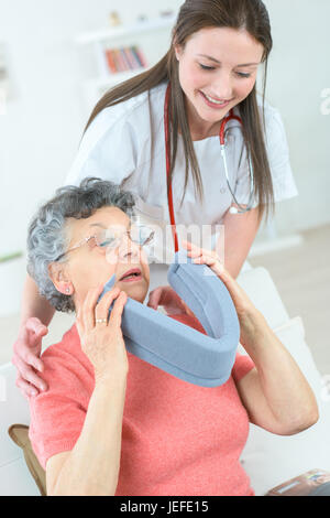 Doctor talking to senior patient in wheelchair with collier cervical Banque D'Images