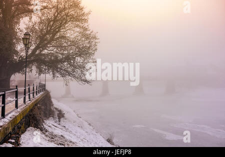 Matin brumeux près du pont à travers la rivière gelée. arbre dans le givre sur l'Embankment. vide neige paysage urbain magnifique lever du soleil Banque D'Images