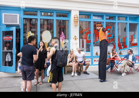 Un artiste du spectacle sur échasses promouvoir l'ouverture des glaces OddFellows fr carnaval dans SoHo à Manhattan Banque D'Images