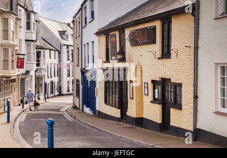 14 Juin 2017 : Ilfracombe, Devon, England, UK - Un homme se promène avec son bas Greyhound Fore Street, anciennement la rue la plus importante de la ville. Banque D'Images