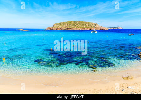 Belle plage de Cala Comte plage avec voile Voile en arrière-plan sur la mer bleu azur, l'île d'Ibiza, Espagne Banque D'Images